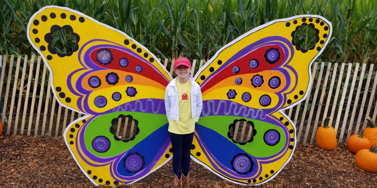 Child at the center of a colorful butterfly photo op
