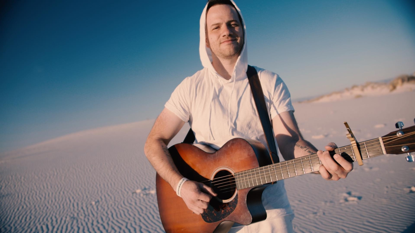 Ian Biggs on the guitar on the beach